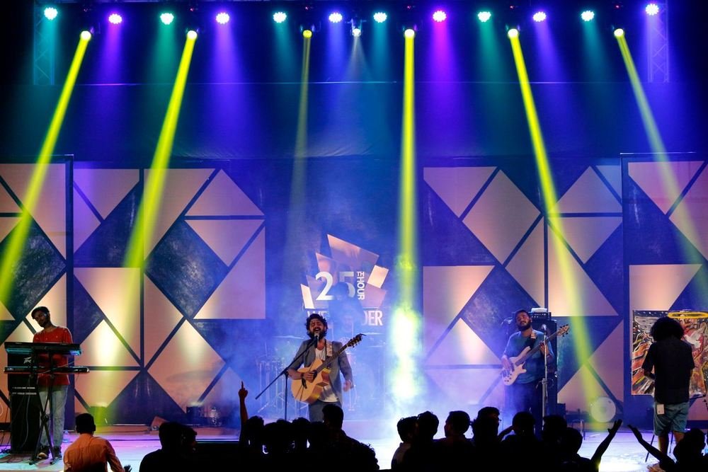 Singer and band performing under stage lights