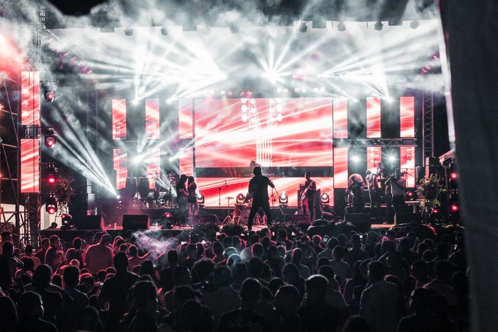Band on a lit stage in front of a crowd