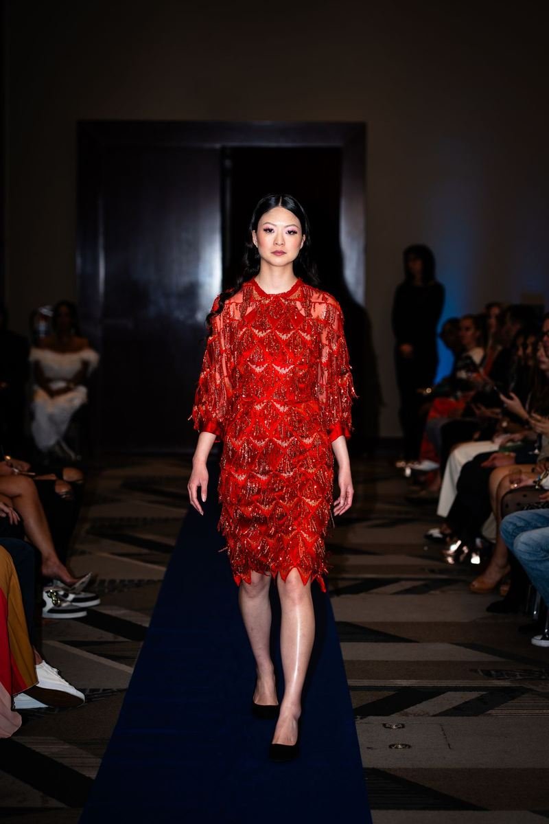 Model in a red dress walking the runway