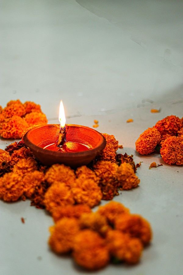 Lit diya among marigold flowers