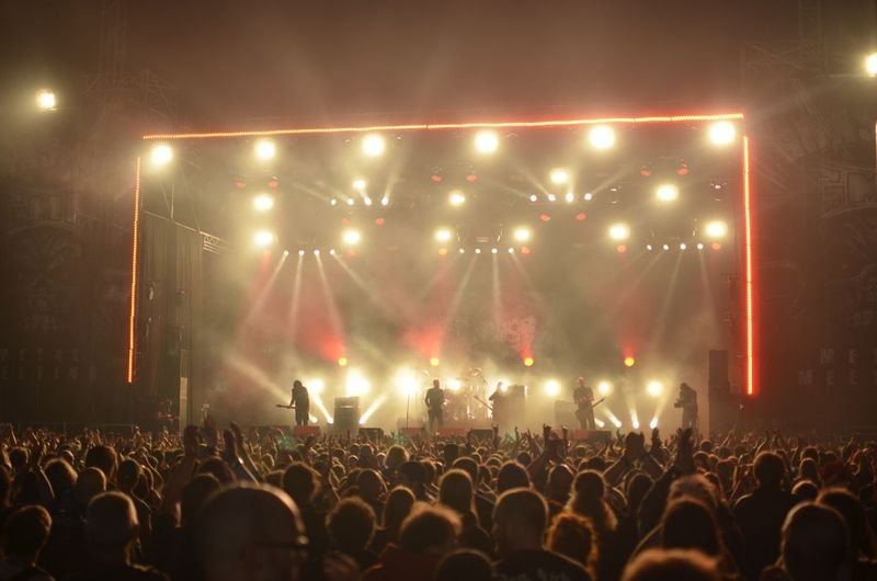 Crowd facing a warmly lit concert stage