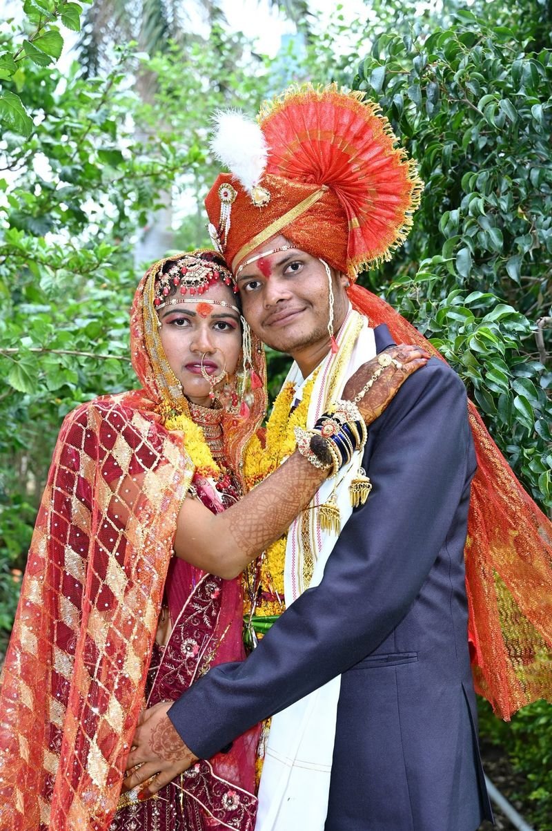 Bride and groom in wedding clothes with flower garlands