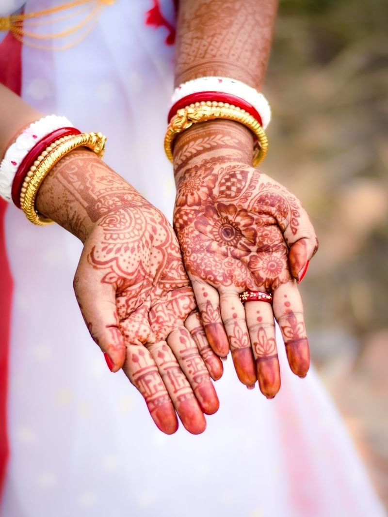 Hennaed hands with red and white bangles
